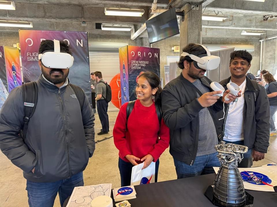 a group of four adults playing with virtual reality goggles at the NASA Stennis booth