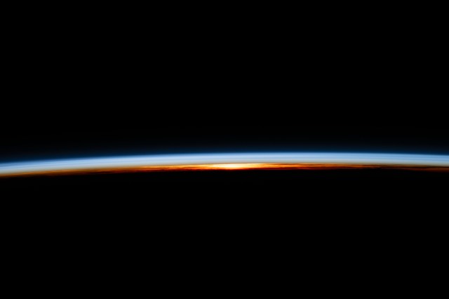 The last rays of an orbital sunset illuminate Earth's atmosphere and reveal the cloud tops in this photograph from the International Space Station as it orbited 258 miles above the Atlantic Ocean.