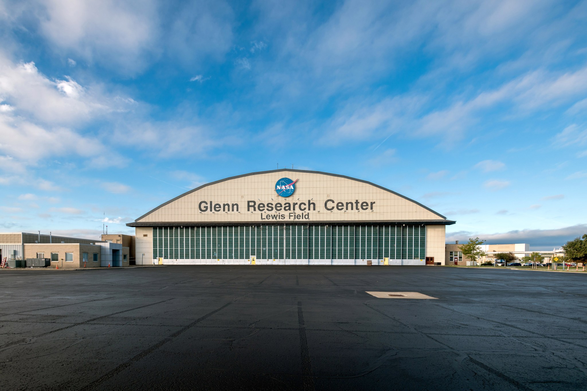 The large hangar displays the NASA emblem at the top. A blue sky in the background.