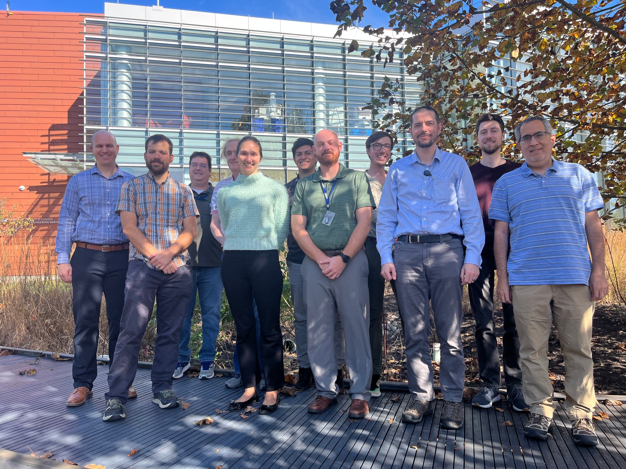 Nearly a dozen NASA researchers associated with developing the Aviary computer modeling tool pose for a photo outside their office building.