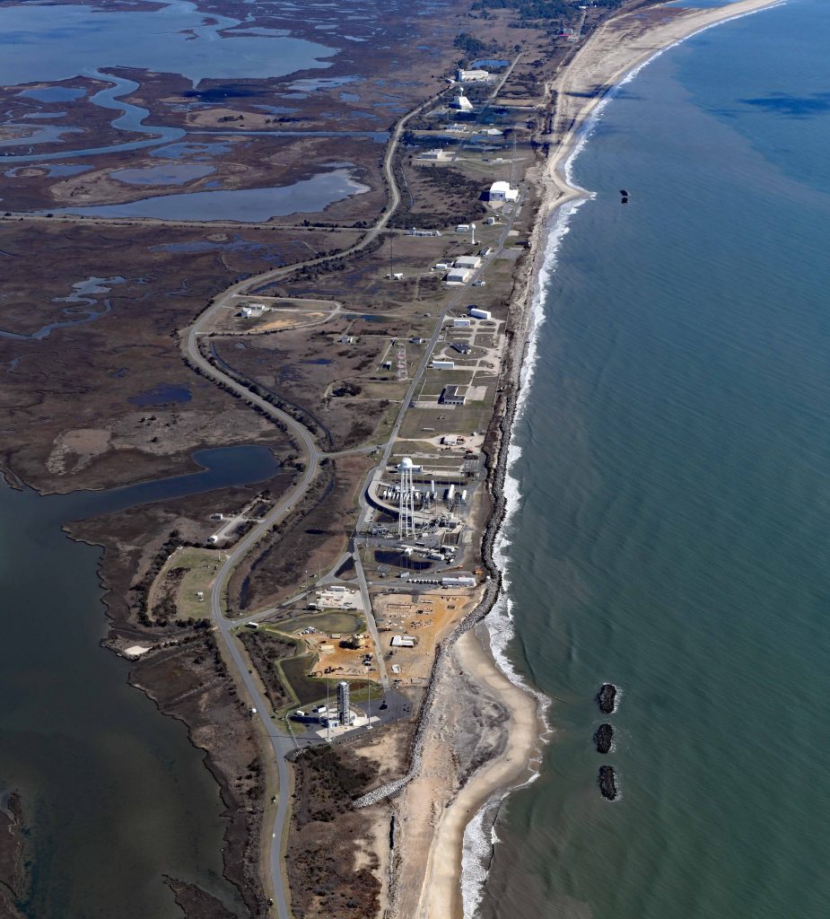 An island with rocket launch pads on the south east, buildings in the center, the Atlantic Ocean to the east, and marshes to the west.