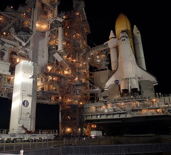 The payload canister, left, arrives at Launch Pad 39A, where Atlantis awaits for the second launch attempt
