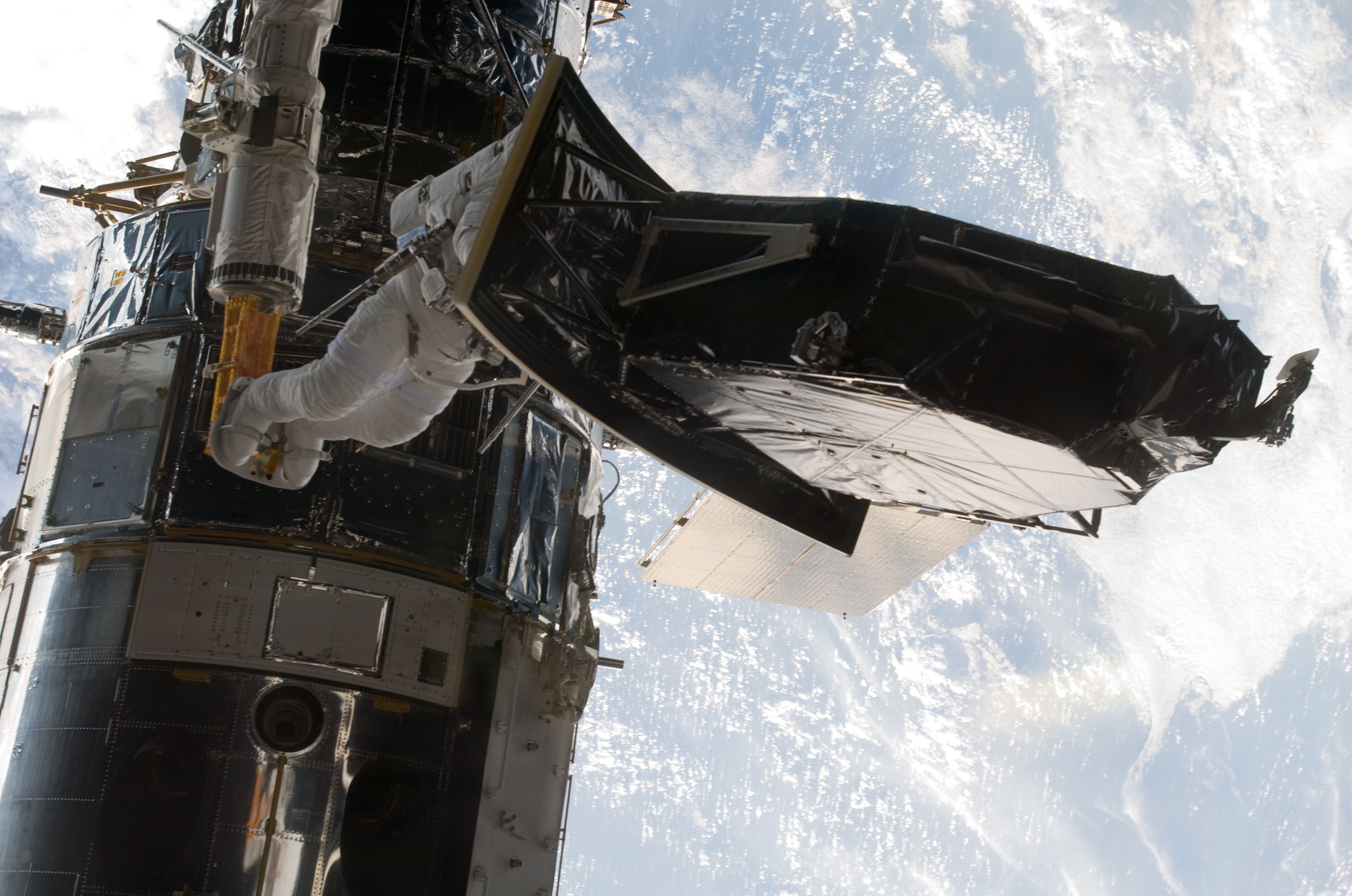 Andrew J. Feustel carries the Wide Field and Planetary Camera-2 (WFPC-2) that he and John M. Grunsfeld removed from Hubble