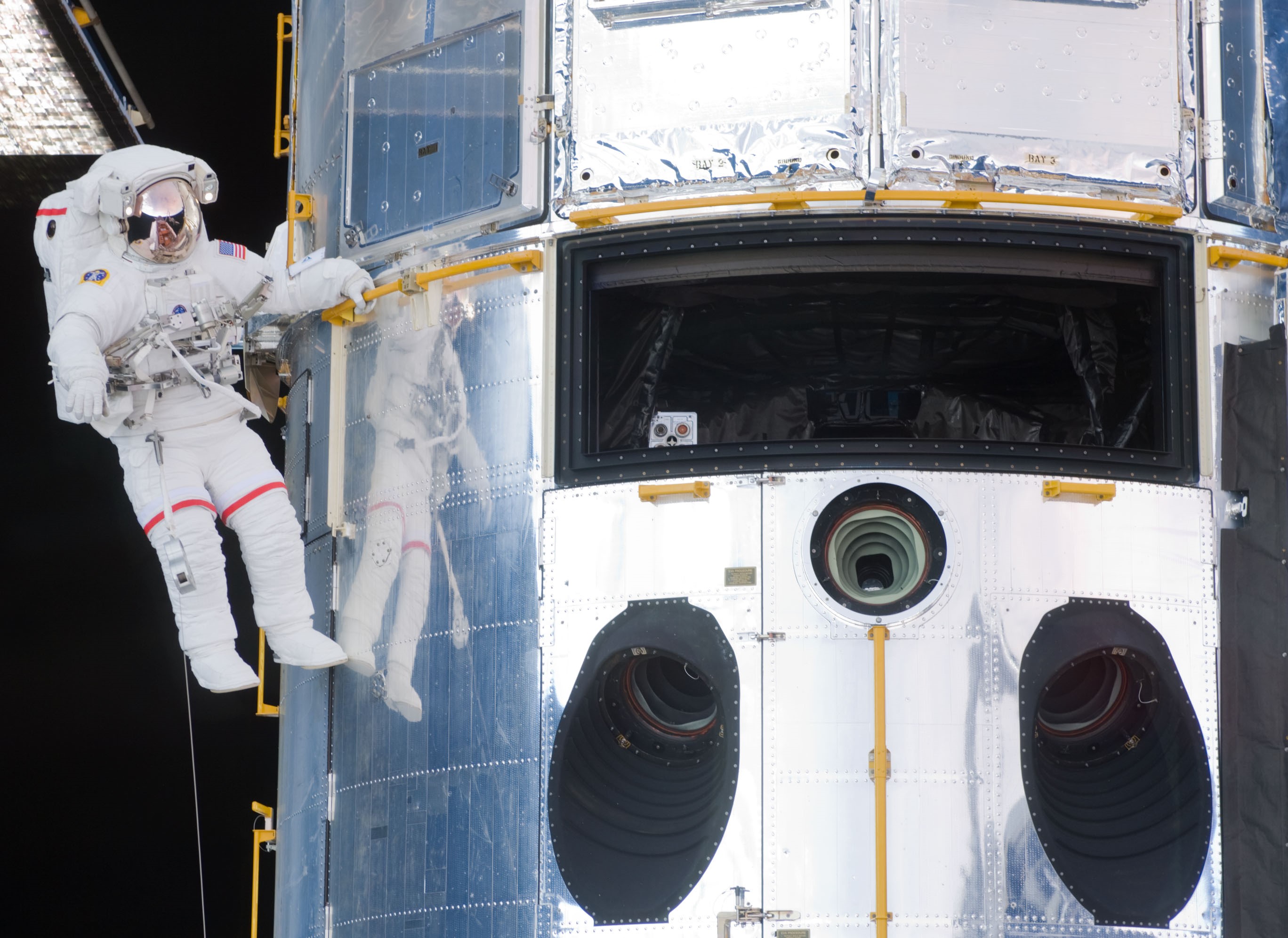 Grunsfeld floats next to Hubble, with a large opening where he and Feustel removed WFPC-2 and later installed the Wide Field Camera-3 (WFC-3)