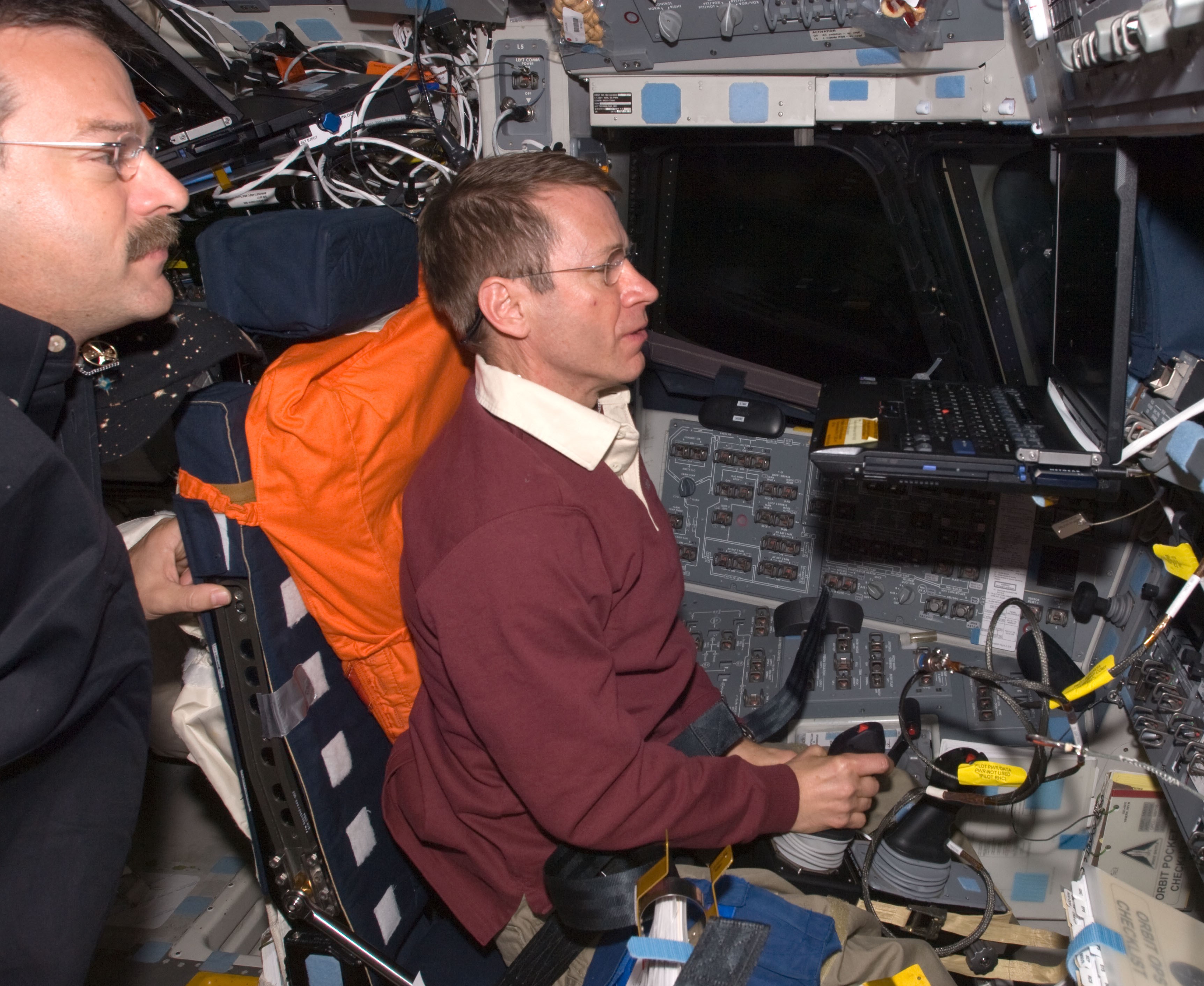 Commander Scott D. Altman, left, assists Pilot Gregory C. Johnson during a computer-based landing simulation