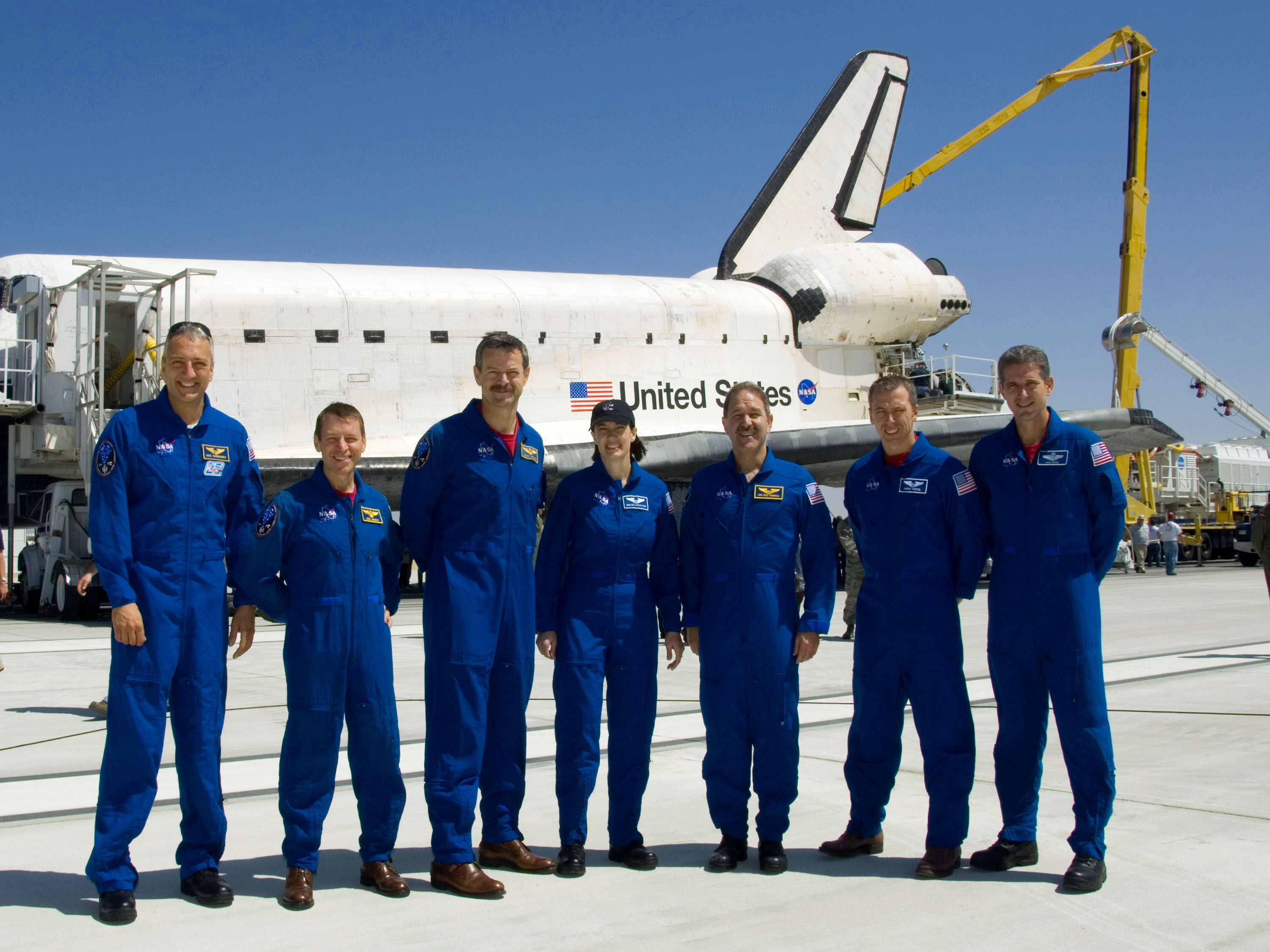 The STS-125 crew poses in front of Atlantis at Edwards after their successful mission