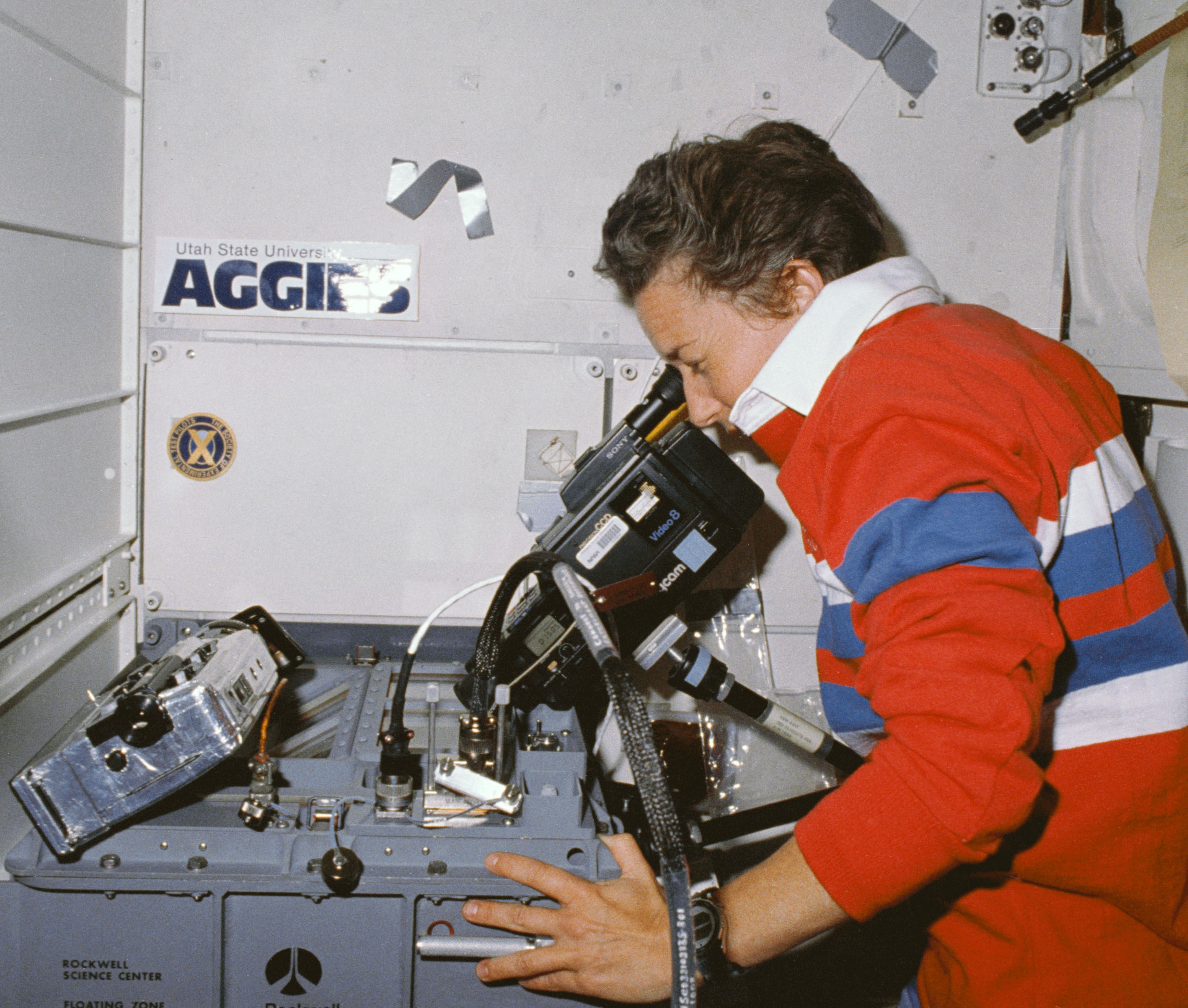 NASA Space Technology Mary L. Lop videotapes the event of an experiment in the Fluids Experiment Apparatus