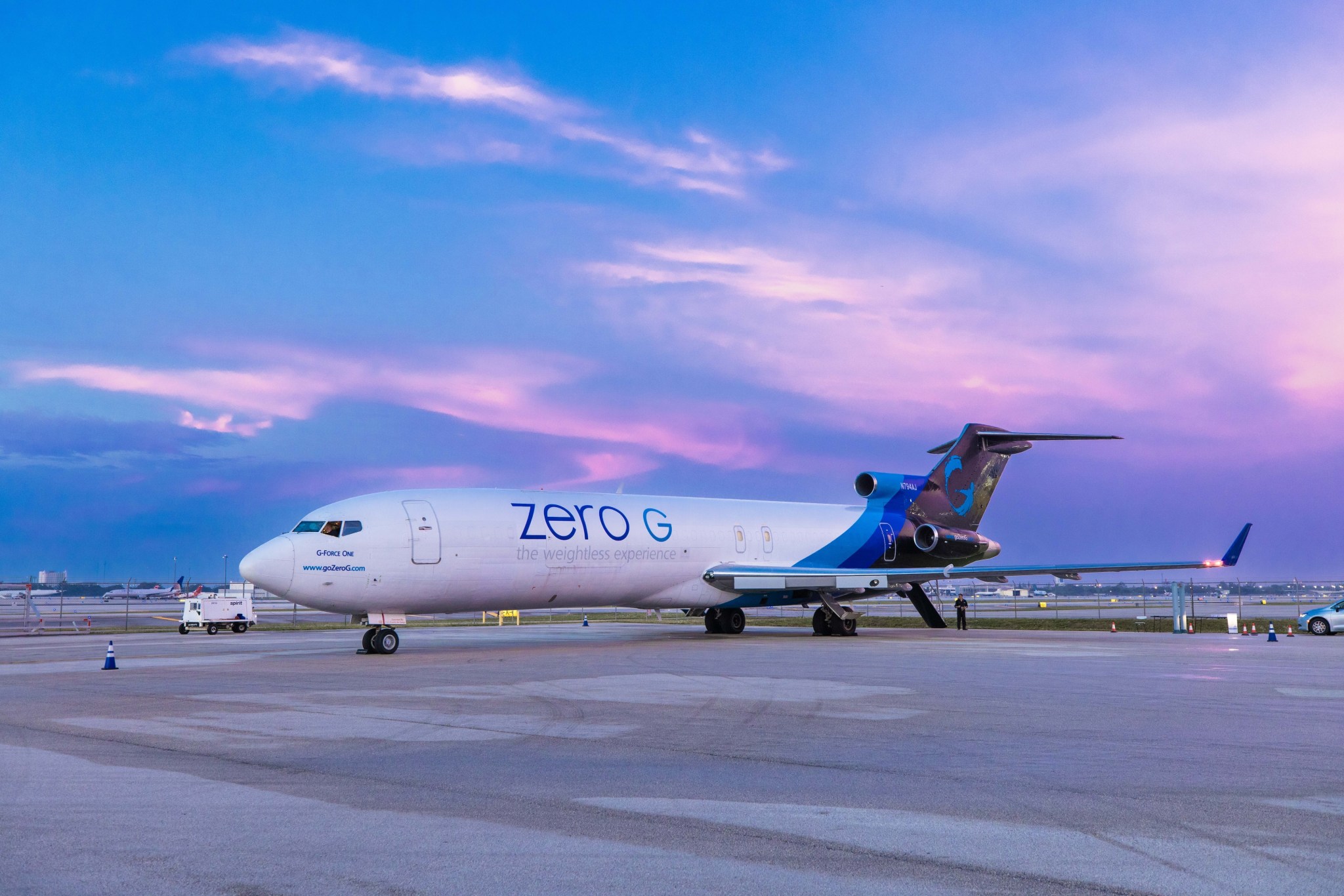 Jet sits on runway against a purple sunrise
