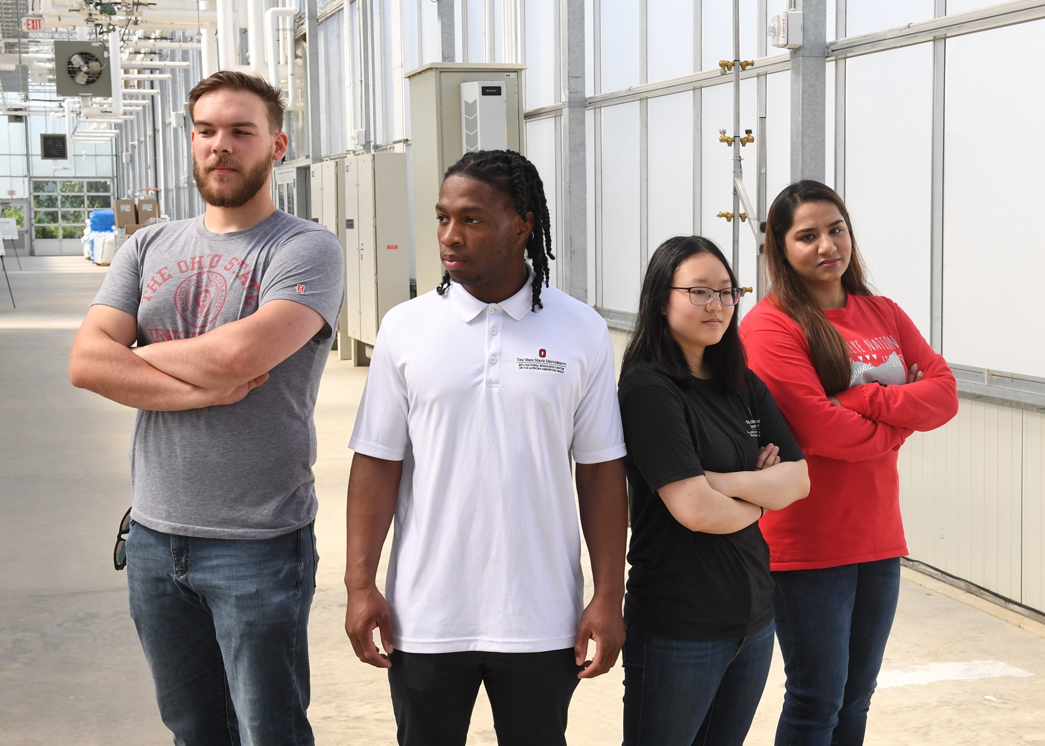 The four Deep Space Food Challenge Simunauts stand next to each other, each looking in different directions away from the camera. From left to right: Charlie Frick, Fuanyi Fobellah, Sakura Sugiyama, and Mehr Un Nisa.