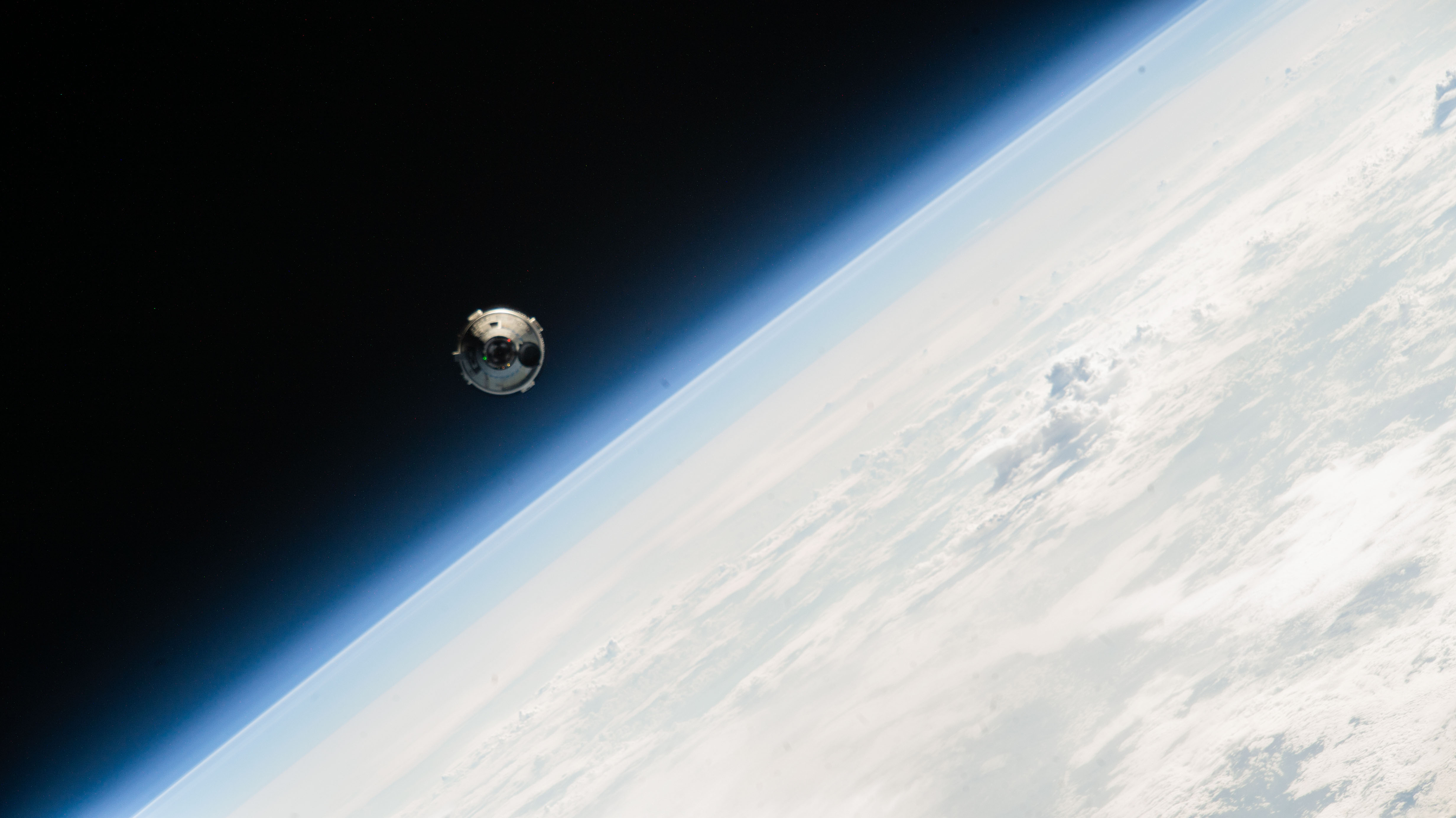 Boeing's Starliner spacecraft as it approaches the International Space Station. Also in view is the Earth below it.