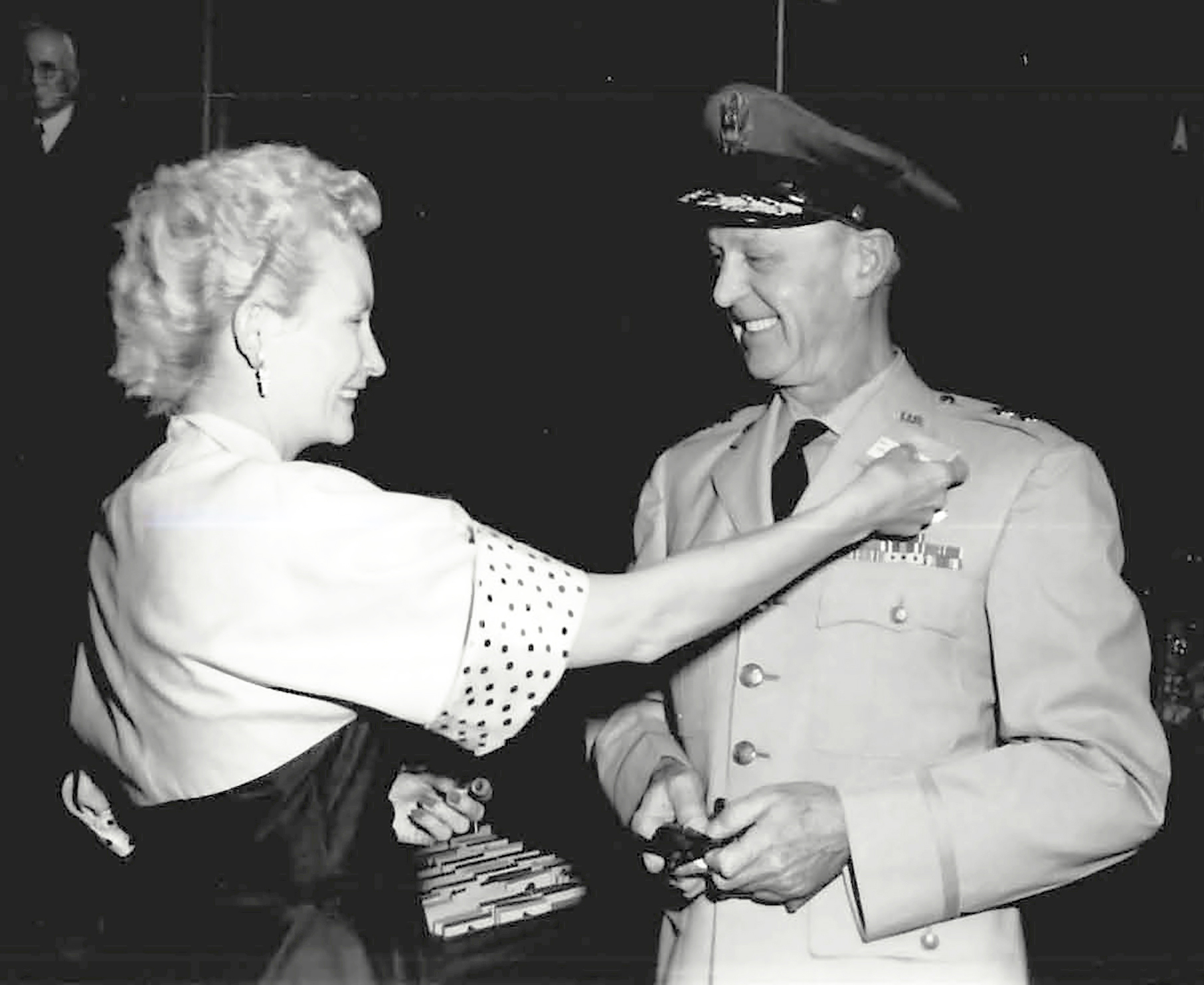 Woman pinning badge on man.