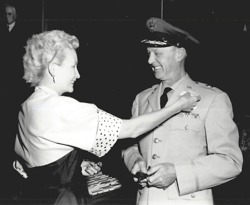 Woman pinning badge on man.