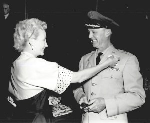 Woman pinning badge on man.