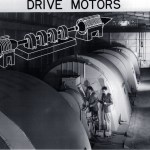 Two men with large drive motor.