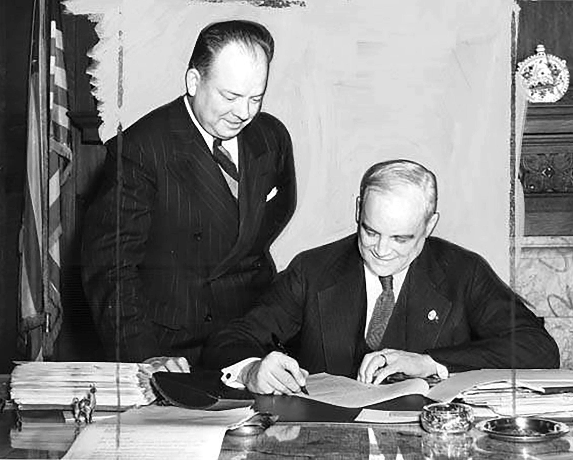 Two men reviewing document at desk.