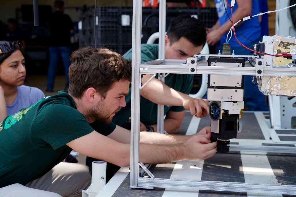 Two men adjust the lens on the Bronco Ember technology, which uses a short-wave infrared camera with AI to improve early wildfire detection.