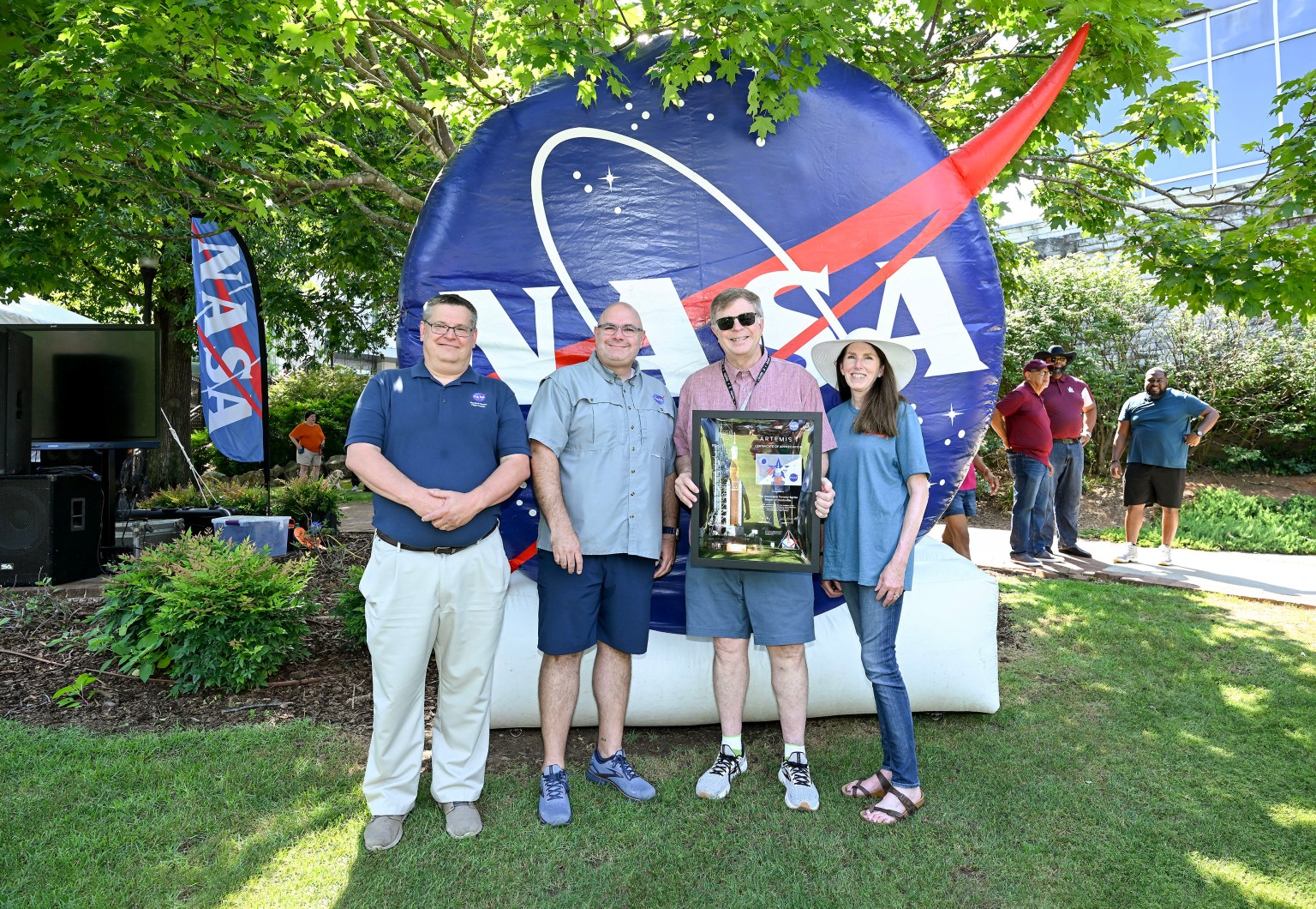 NASA Marshall Space Flight Center Director Joseph Pelfrey, second from left, presented Huntsville Mayor Tommy Battle, third from left, with an Artemis I Certificate of Appreciation during NASA in the Park on June 22 at Huntsville’s Big Spring Park East. They are joined by Larry Leopard, Marshall associate director, technical, far left, and Rae Ann Meyer, Marshall deputy director.