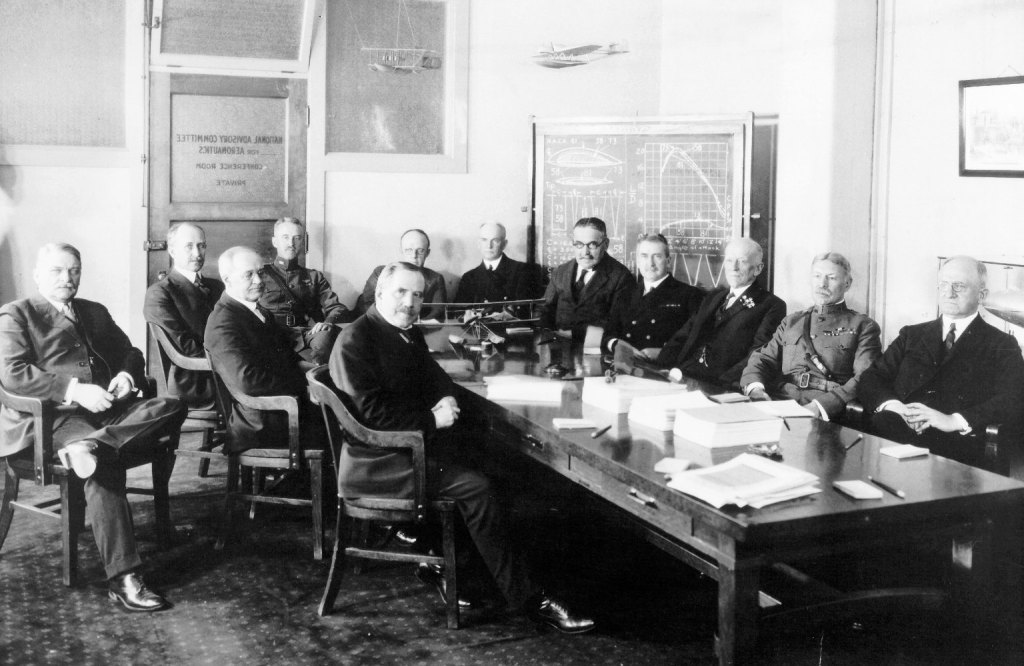 Group of men sitting at conference table.