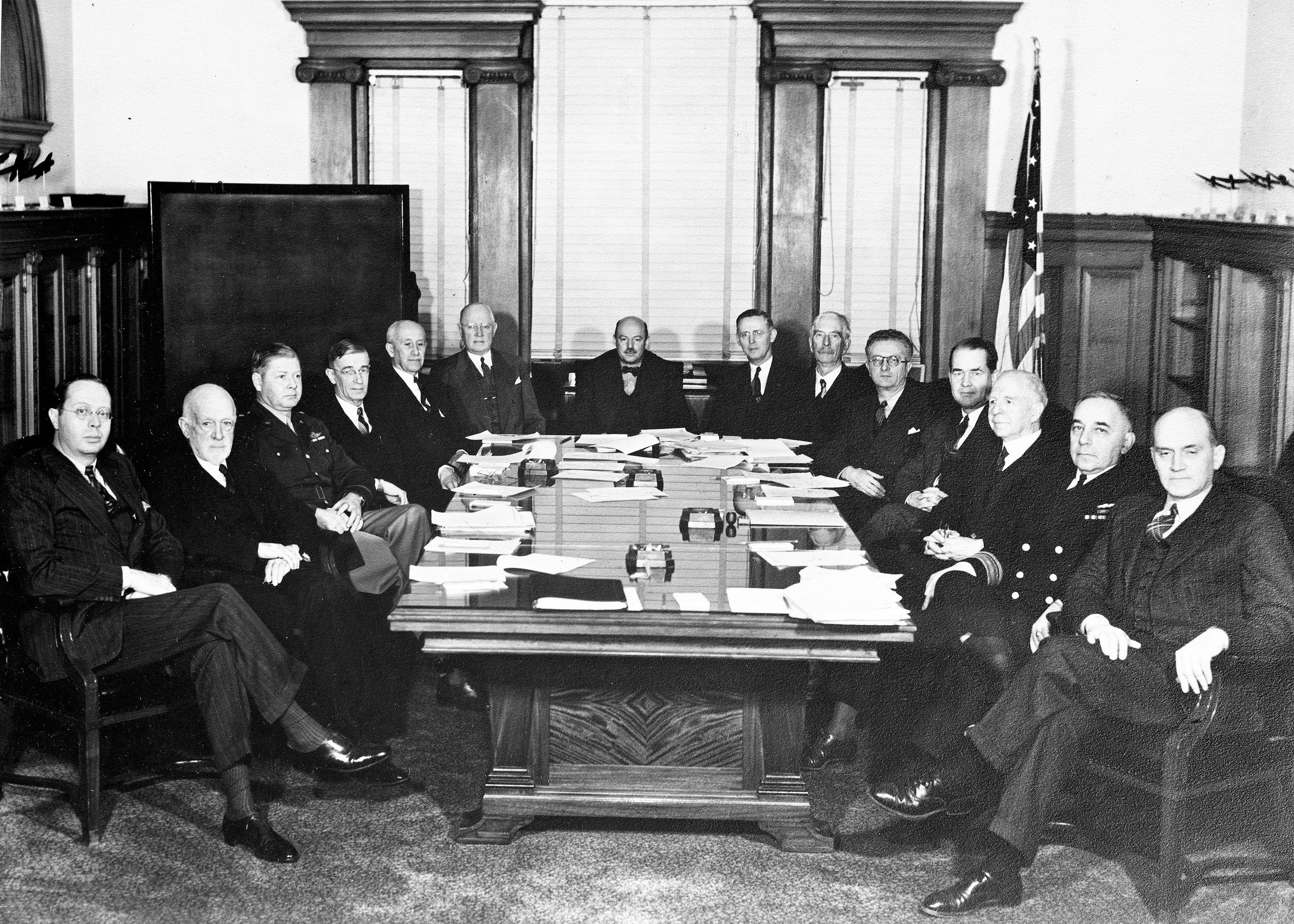 Group of men sitting at conference table.
