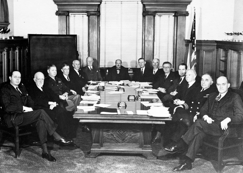 Group of men sitting at conference table.