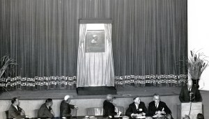 Men seated at table in front of stage.