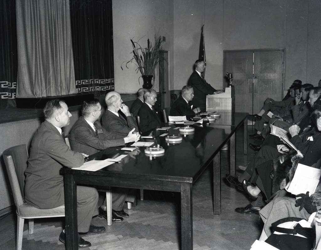 People seated at table near stage.