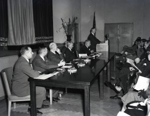 People seated at table near stage.