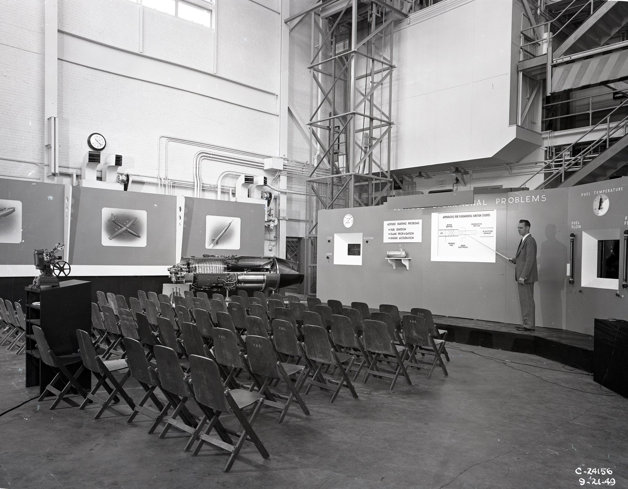 Man with display and empty chairs.