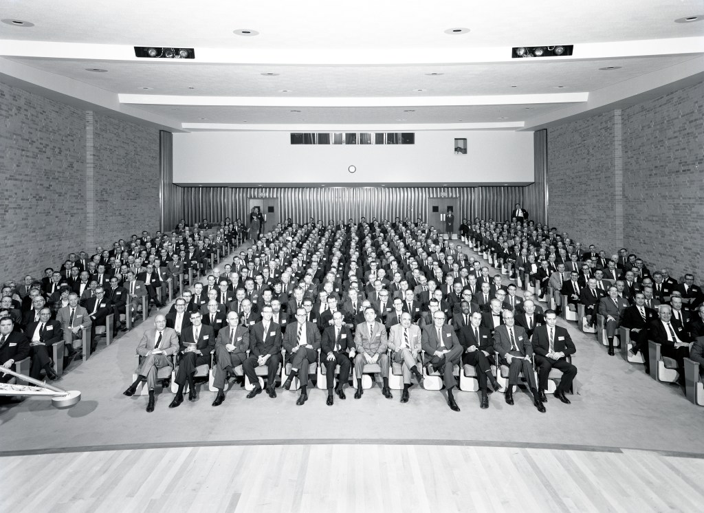 Crowd seated in auditorium.