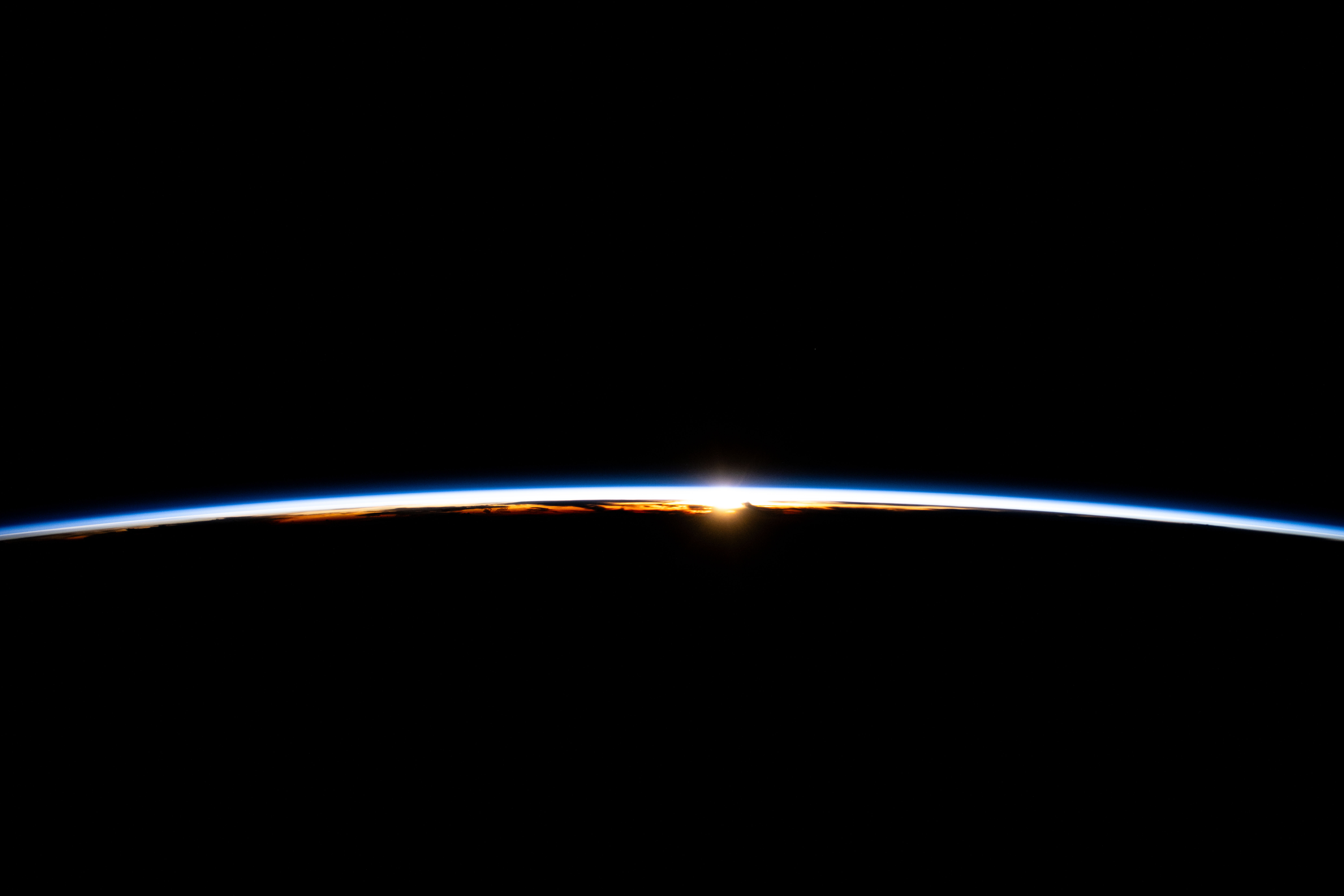 The first rays of an orbital sunrise break through Earth's atmosphere highlighting the cloud tops in this photograph from the International Space Station as it soared 256 miles above the Indian Ocean off the coast of Sumatra, Indonesia.