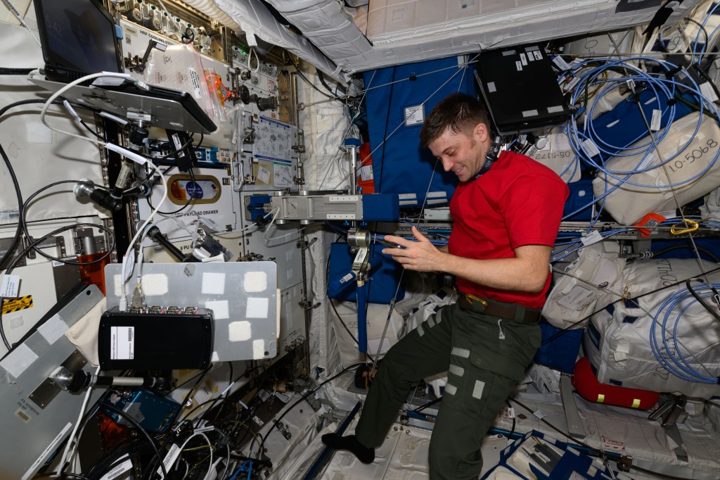 Expedition 71 Flight Engineer and NASA astronaut Matthew Dominick works in the International Space Station's Columbus laboratory module performing maintenance on the Space Linear Acceleration Mass Measurement Device, or SLAMMD. The human research device applies a known force to a crew member then calculates body mass using a form of Newton’s Second Law of Motion, force equals mass times acceleration.