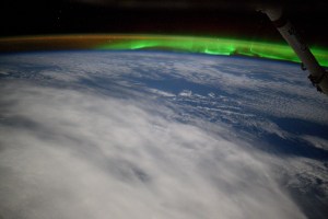An aurora and an atmospheric glow crown Earth's horizon in this photograph from the International Space Station as it orbited 263 miles above a cloudy Indian Ocean southeast of Africa.