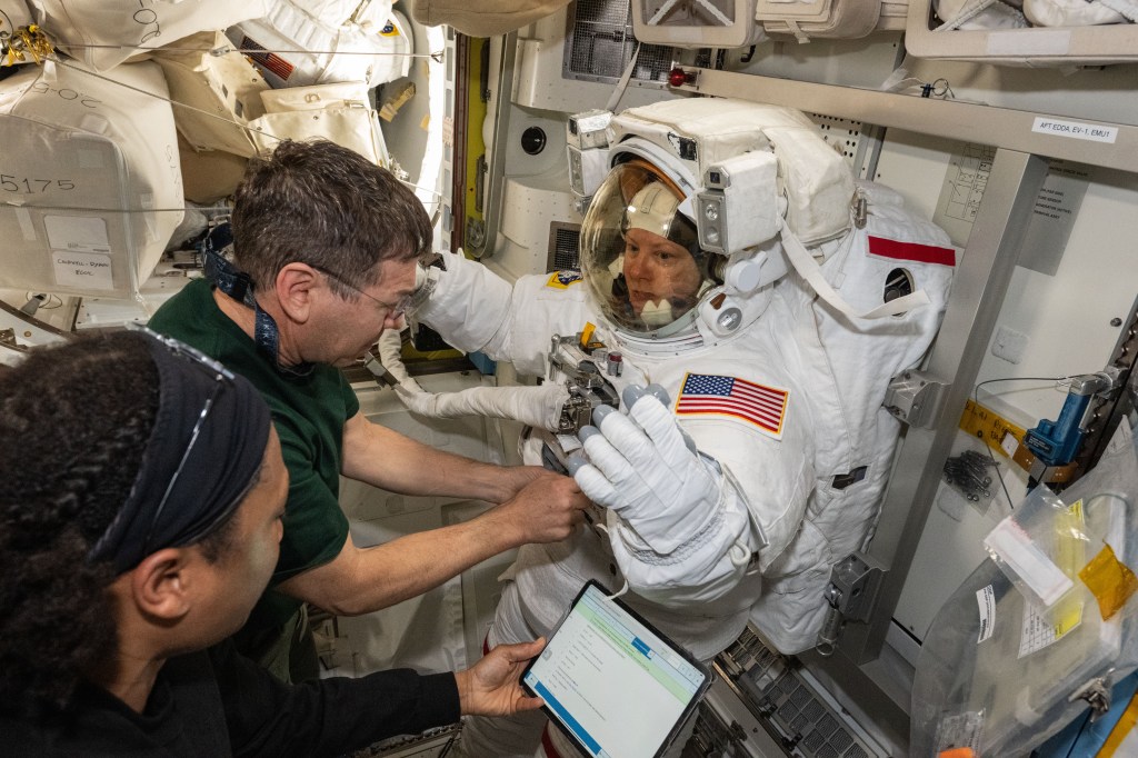 Expedition 71 Flight Engineers (from left) Jeanette Epps and Mike Barratt assist Expedition 71 Flight Engineer Tracy C. Dyson, all three NASA astronauts, during a spacesuit fit check inside the International Space Station's Quest airlock.