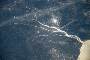 A sun glint-lit Moose River flows into James Bay in Ontario, Canada, in this photograph from the International Space Station as it orbited 264 miles above North America.