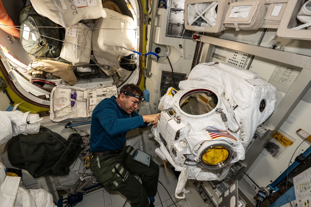 Expedition 71 Flight Engineer and NASA astronaut Mike Barratt replaces components on a spacesuit inside the International Space Station's Quiest airlock.