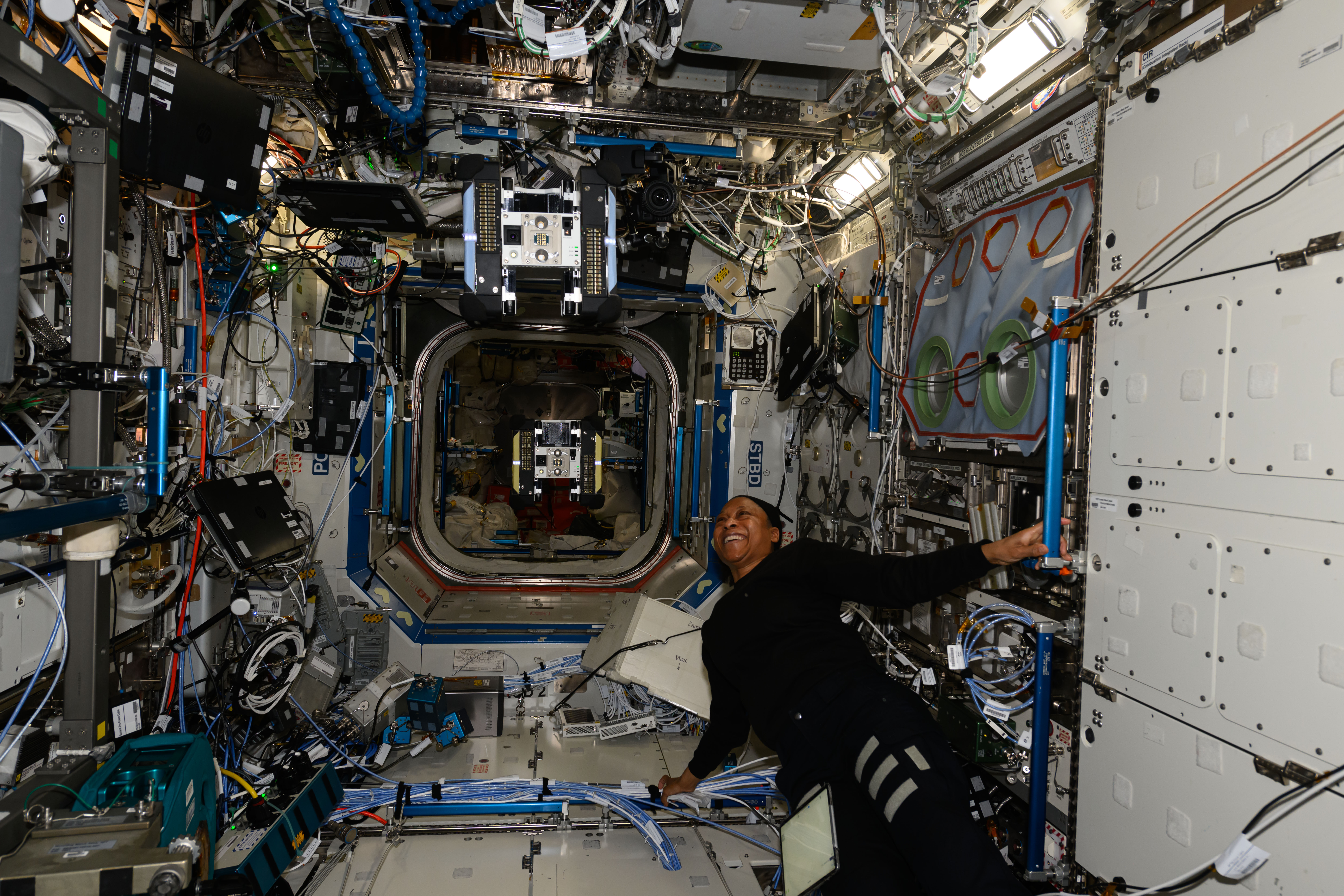 Expedition 71 Flight Engineer and NASA astronaut Jeanette Epps observes an Astrobee robotic free flyer during an operations test inside the International Space Station's Kibo laboratory module.