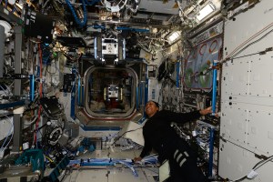 Expedition 71 Flight Engineer and NASA astronaut Jeanette Epps observes an Astrobee robotic free flyer during an operations test inside the International Space Station's Kibo laboratory module.