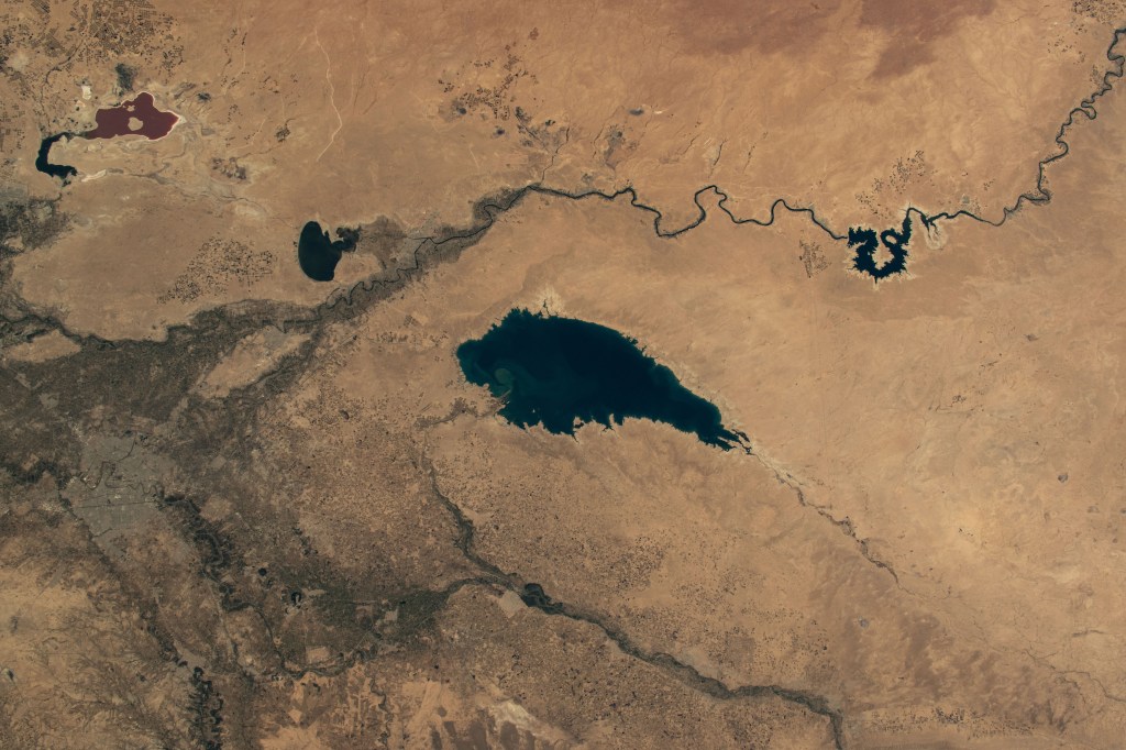 Baghdad, Iraq (lower left), is pictured near several bodies of water including (from left) Razazza Lake, Habbaniyah Lake, Therthar Lake, the Euphrates River, and Lake Qadisiyah created by the damming of the Euphrates. The International Space Station was orbiting 260 miles above the Middle East at the time of this photograph.