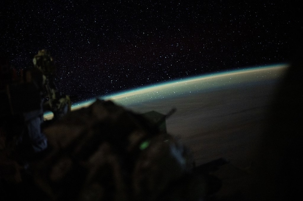 Stars sparkle above Earth's atmospheric glow in this long-duration photograph taken from the International Space Station as it orbited 266 miles above the Indian Ocean and due south of Australia's island state of Tasmania.