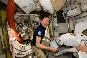NASA astronaut and Expedition 71 Flight Engineer Tracy C. Dyson works inside the International Space Station's Quest airlock and checks procedures on a computer tablet to prepare a spacesuit for a fit verification.