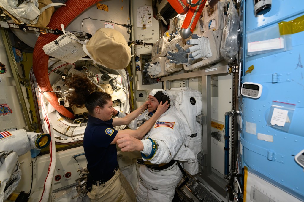 Expedition 71 Flight Engineer Tracy C. Dyson assists Expedition 71 Flight Engineer Mike Barratt, both NASA astronauts, during a spacesuit fit check inside the International Space Station's Quest airlock.