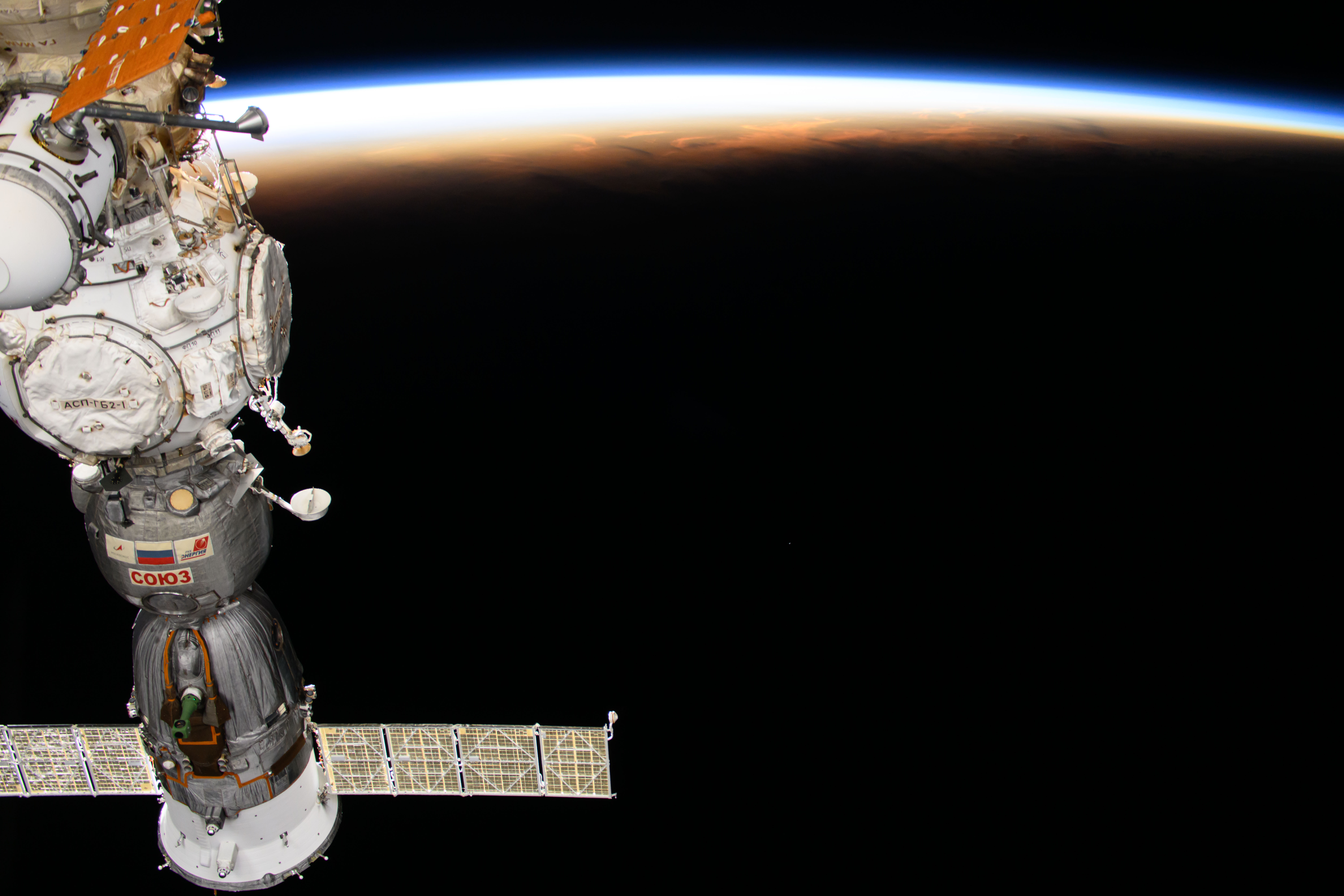 The International Space Station soars into an orbital sunset 258 miles above the Maldives in the Indian Ocean. In the left foreground, is the Soyuz MS-25 crew ship docked to the Prichal docking module.