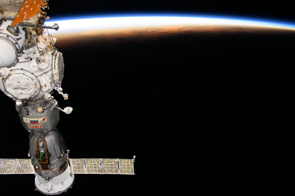 The International Space Station soars into an orbital sunset 258 miles above the Maldives in the Indian Ocean. In the left foreground, is the Soyuz MS-25 crew ship docked to the Prichal docking module.