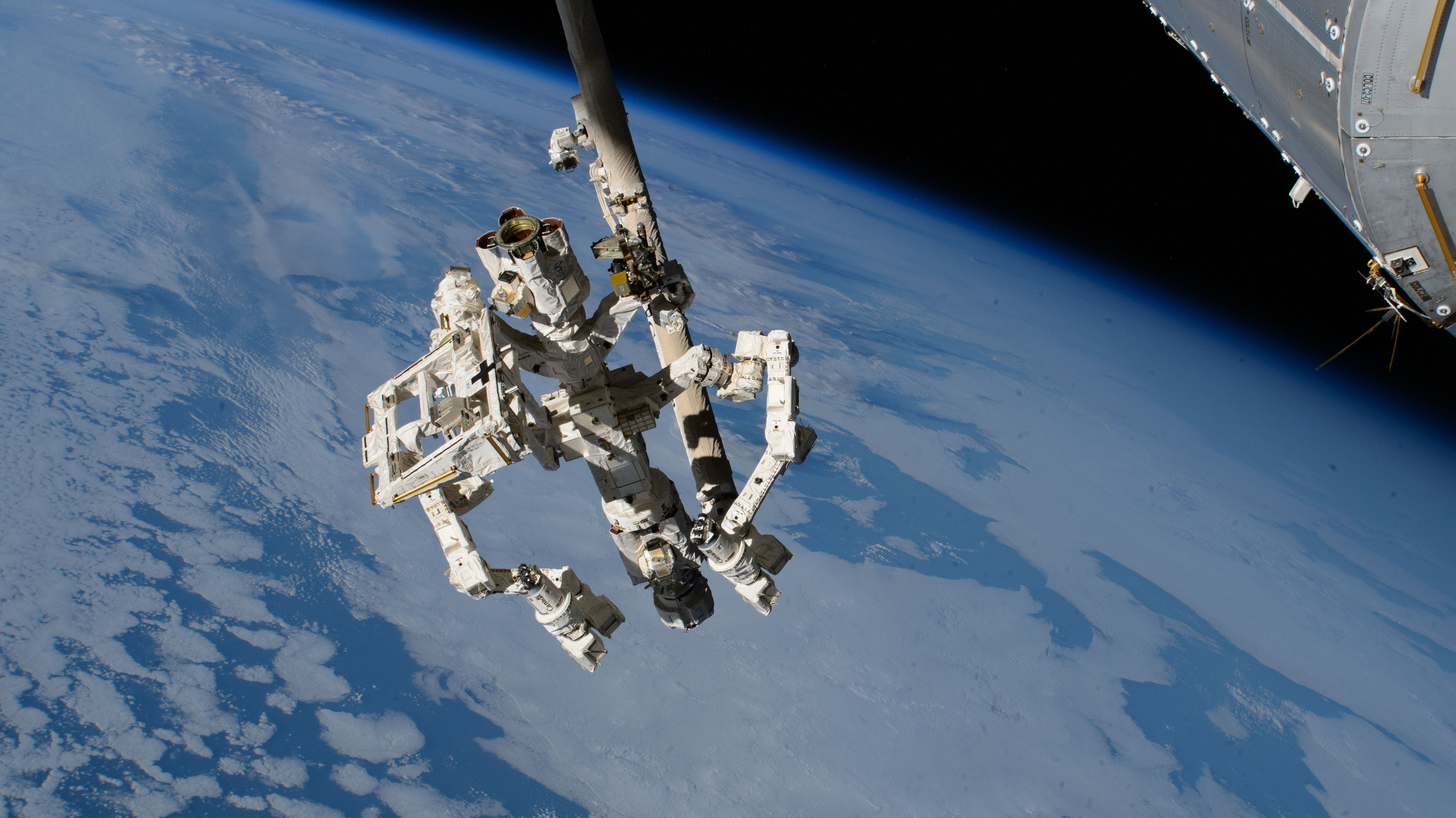 Dextre, the fine-tuned robotic hand attached to the Canadarm2 robotic arm, extends from the International Space Station while orbiting 259 miles above the Pacific Ocean southwest of Baja California.