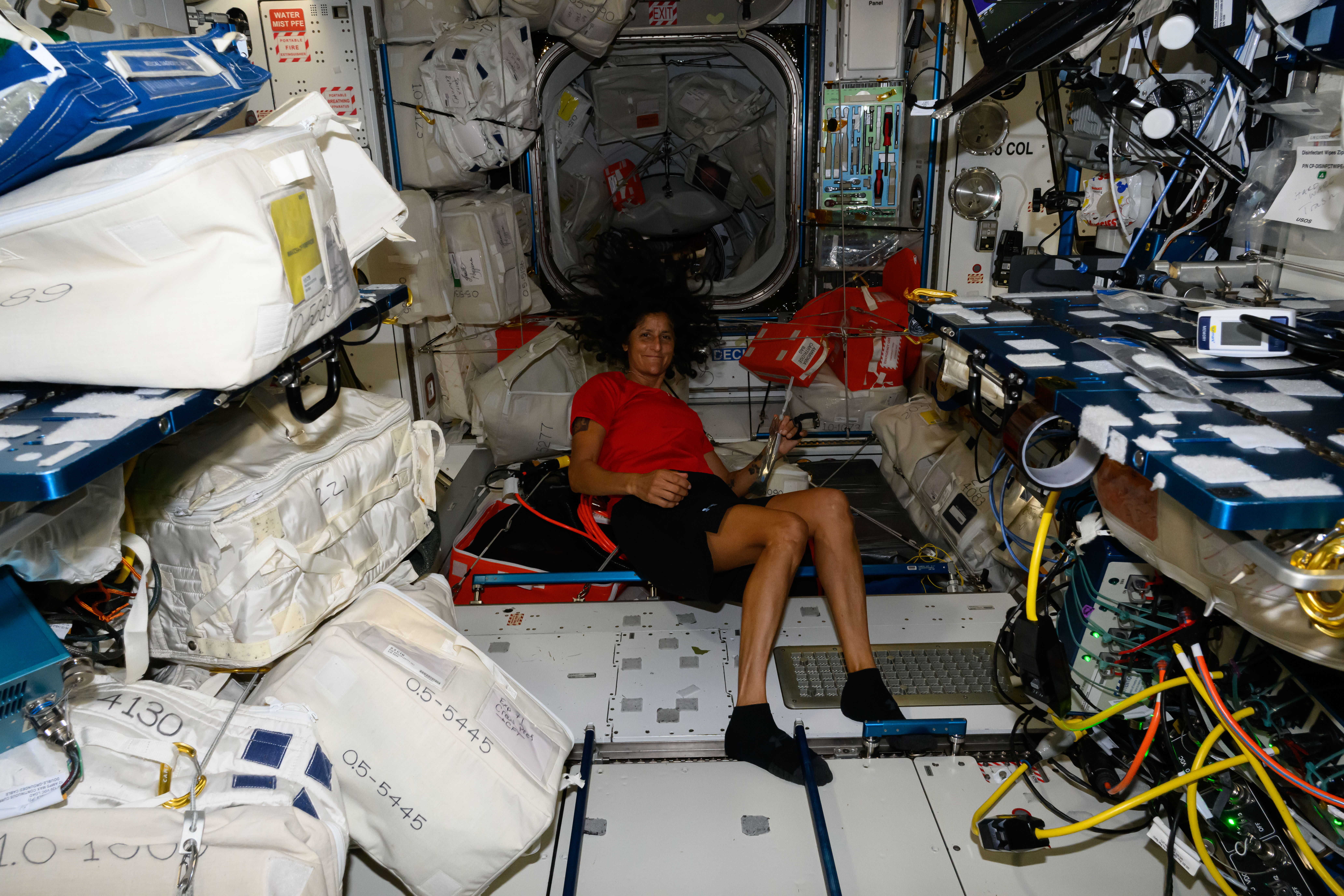 NASA astronaut and Boeing Crew Flight Test Pilot Suni Williams is pictured in front of the Harmony module's vestibule that leads to the forward port where Boeing's Starliner spacecraft is docked to the International Space Station.