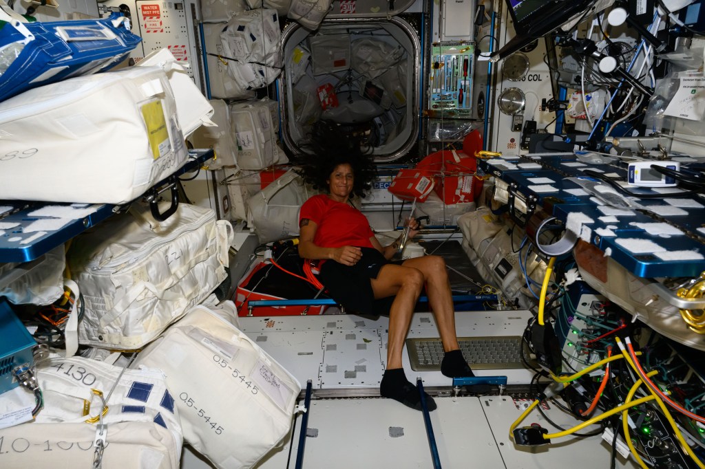 NASA astronaut and Boeing Crew Flight Test Pilot Suni Williams is pictured in front of the Harmony module's vestibule that leads to the forward port where Boeing's Starliner spacecraft is docked to the International Space Station.