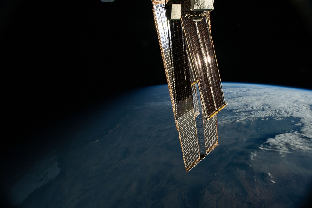 The first rays of an orbital sunrise reflect off the International Space Station's roll-out solar arrays that overshadow and augment the orbital outpost's main solar arrays. The space station was soaring 260 miles above Arizona northeast of Phoenix at the time of this photograph.