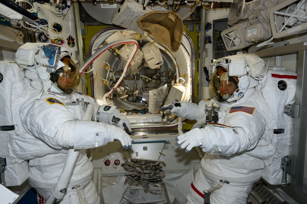 NASA astronauts (from left) Mike Barratt and Tracy C. Dyson, both Expedition 71 Flight Engineers, are pictured in the Quest airlock prior to the start of a science and maintenance spacewalk that ended early after Dyson's suit experienced a water leak in the service and cooling umbilical unit.