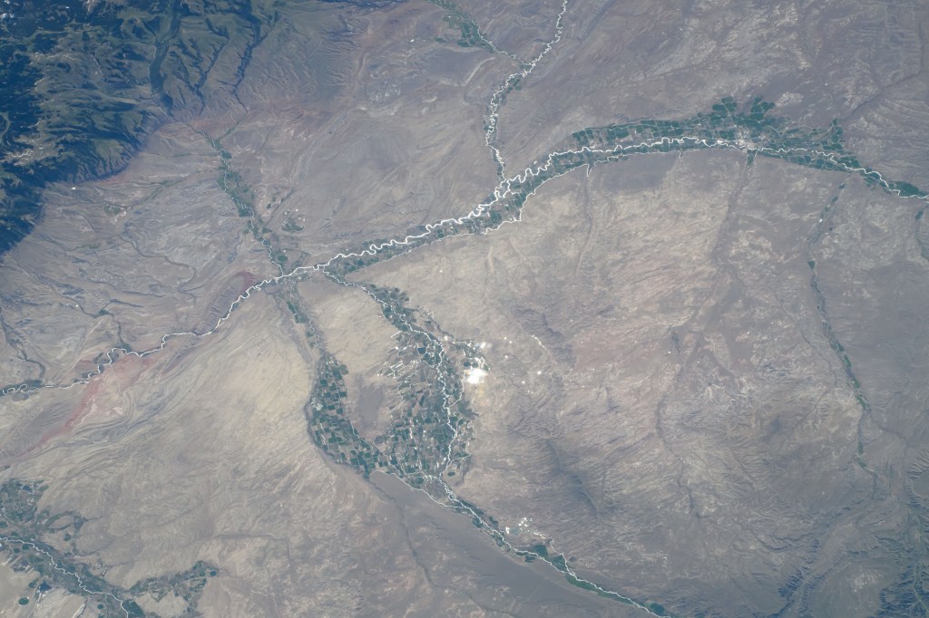 Towns and farmland along the Bighorn River and near the Bighorn National Forest (upper left) in Wyoming are pictured from the International Space Station as it orbited 264 miles above.