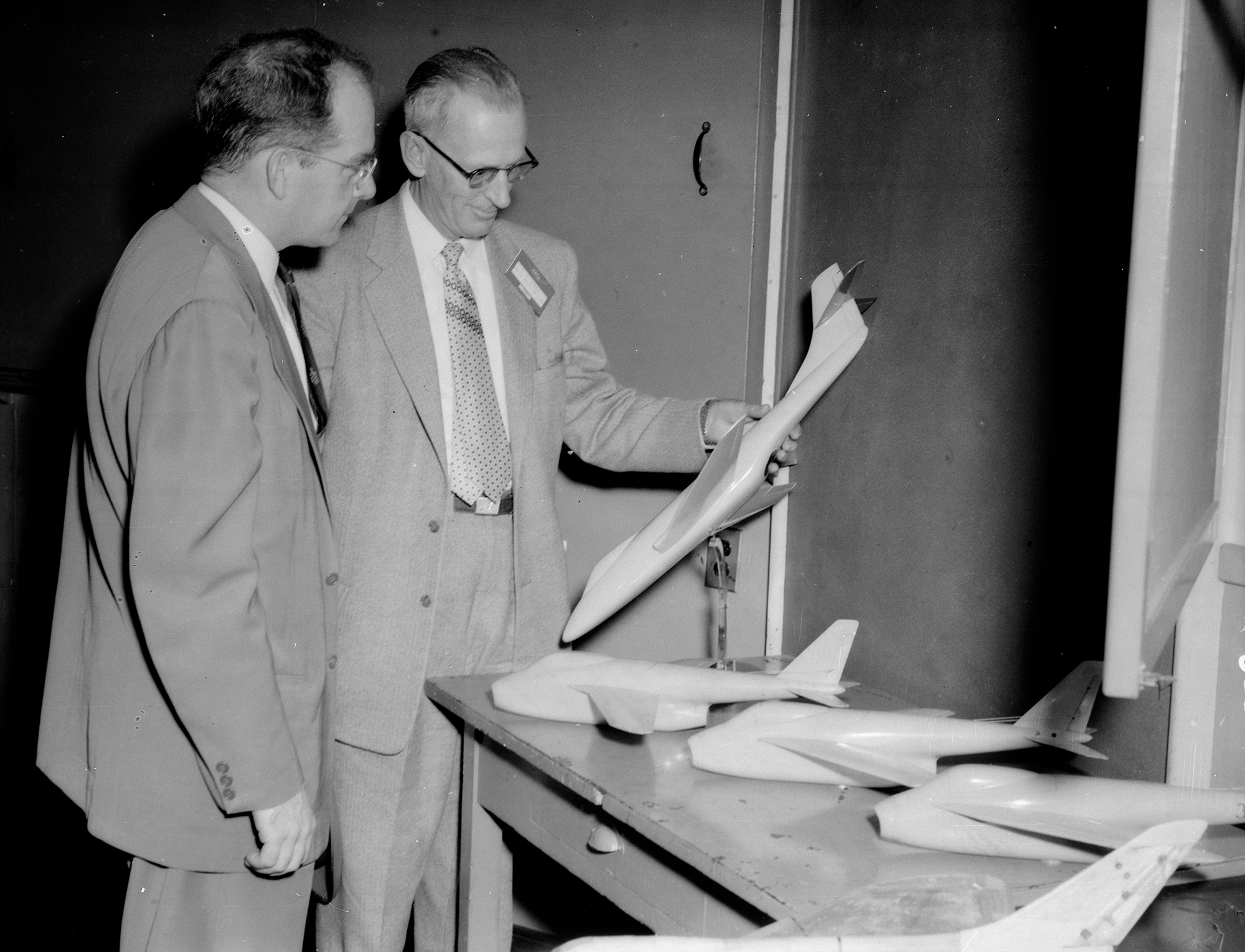 Two men examining airplane model